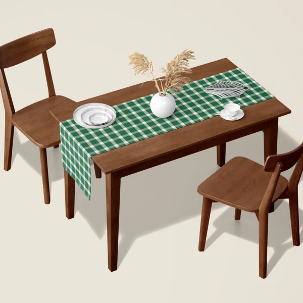 Evergreen gingham Christmas table runner on a walnut dining table with two wooden chairs