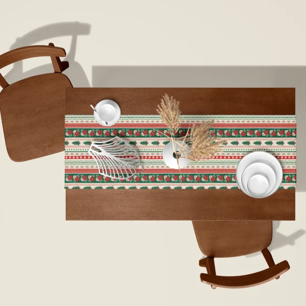 Folk border Christmas table runner seen from above on a walnut table with white dishes and dried pampas