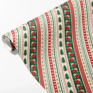Roll of cream folk border wrapping paper with bands of trees, red blooms, gingham and berries, partly unrolled on white