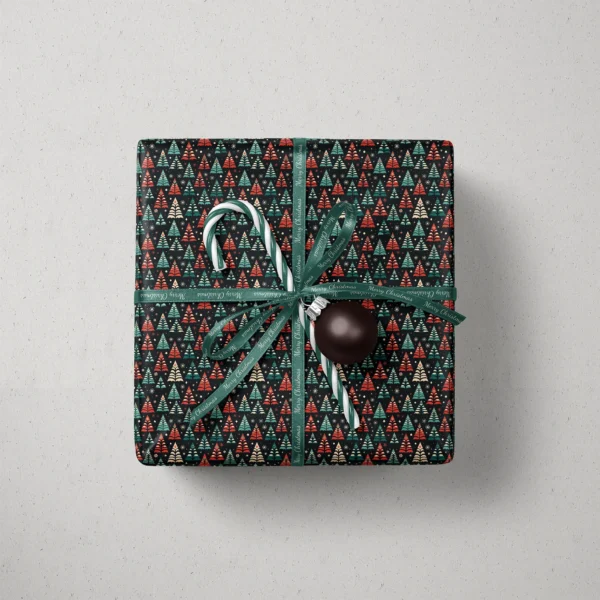 Top view of a gift in black folk tree paper with a ribbon, a candy cane and a bauble