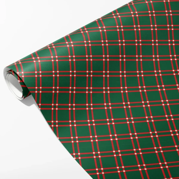 Roll of forest green wrapping paper with red double windowpane lines and small cream squares, partly unrolled on white