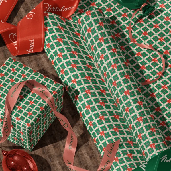 Rolls of green plaid bow gift wrap and a wrapped box with satin ribbons on a wooden floor