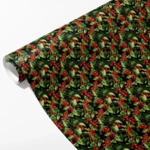 Roll of black wrapping paper with clusters of red holly berries and green leaves, partly unrolled on white