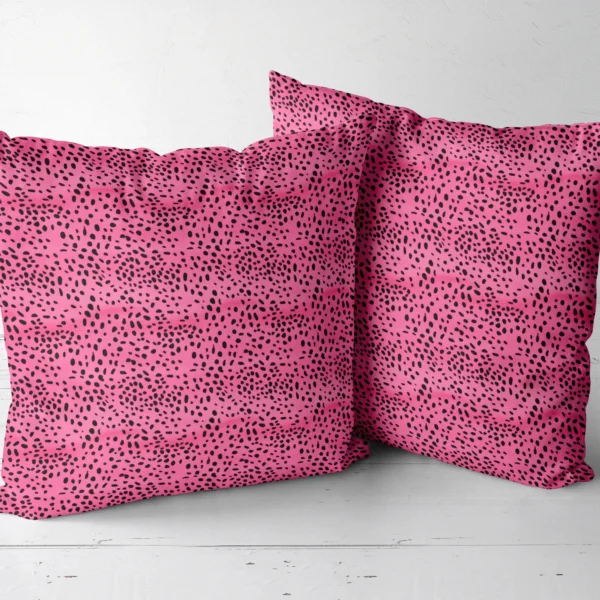 Two hot pink spotted throw pillows next to each other