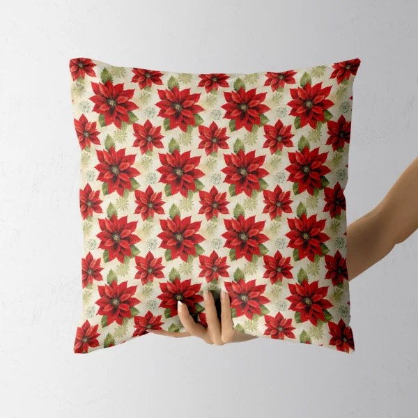Red and cream poinsettia throw pillow in someone's hand