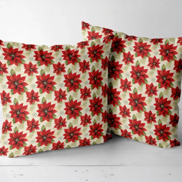 Two cream poinsettia pillows placed side by side