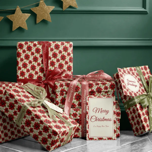 Stack of presents in large cream poinsettia paper with ribbons and a Merry Christmas card by a dark green wall