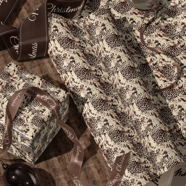 A sheet of brown leopard gift wrap and a wrapped box with satin ribbons on a wooden floor