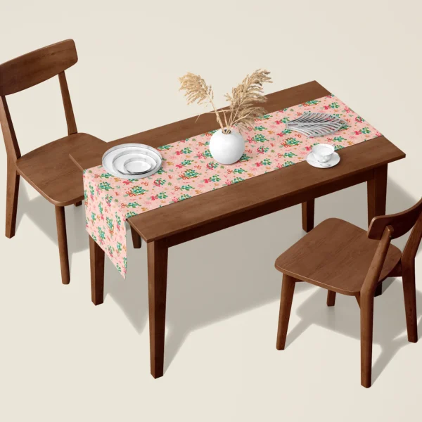 Mistletoe blush Christmas table runner on a walnut dining table with two wooden chairs