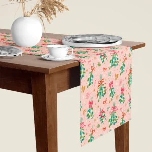 Mistletoe blush Christmas table runner hanging over the end of a walnut dining table, close-up