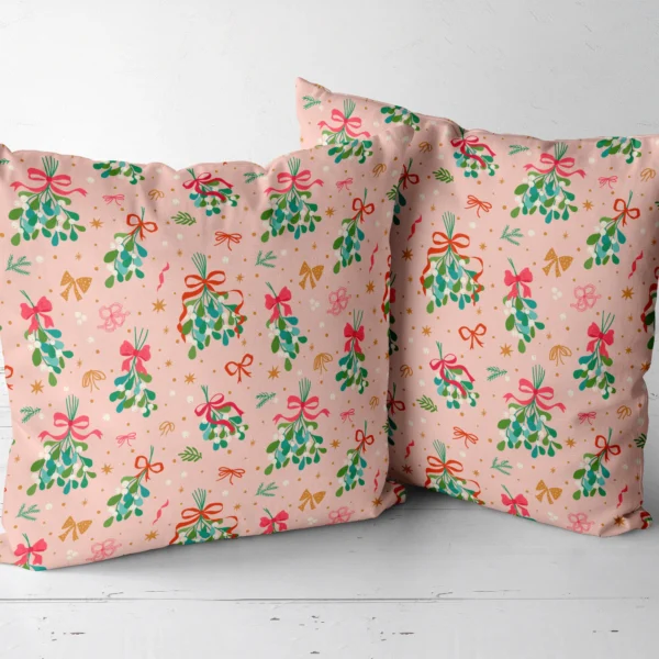 Pair of blush mistletoe throw pillows next to each other