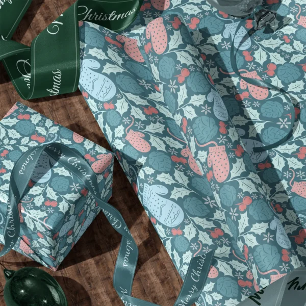 A sheet of teal mitten gift wrap and a wrapped box with satin ribbons on a wooden floor