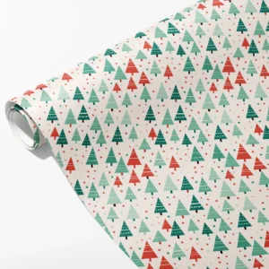 Roll of white wrapping paper with teal, mint and red Christmas trees and red and green dots, partly unrolled on white