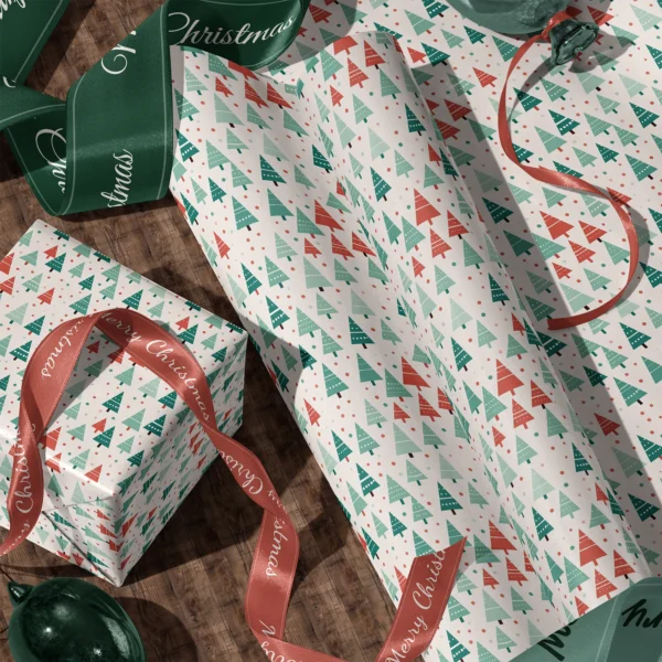 A sheet of white dotted tree gift wrap and a wrapped box with satin ribbons on a wooden floor