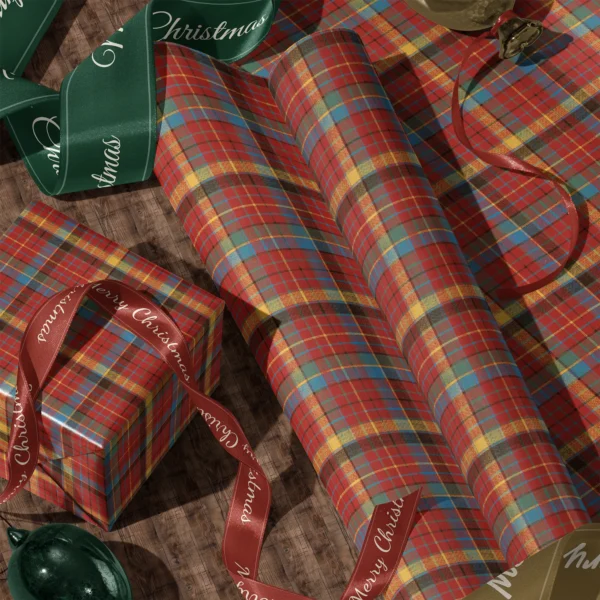Rolls of multicolor plaid gift wrap and a wrapped box with satin ribbons on a wooden floor