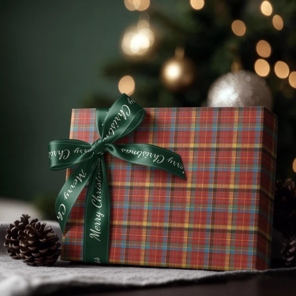 Box wrapped in multicolor plaid paper with a satin ribbon bow, Christmas tree lights behind