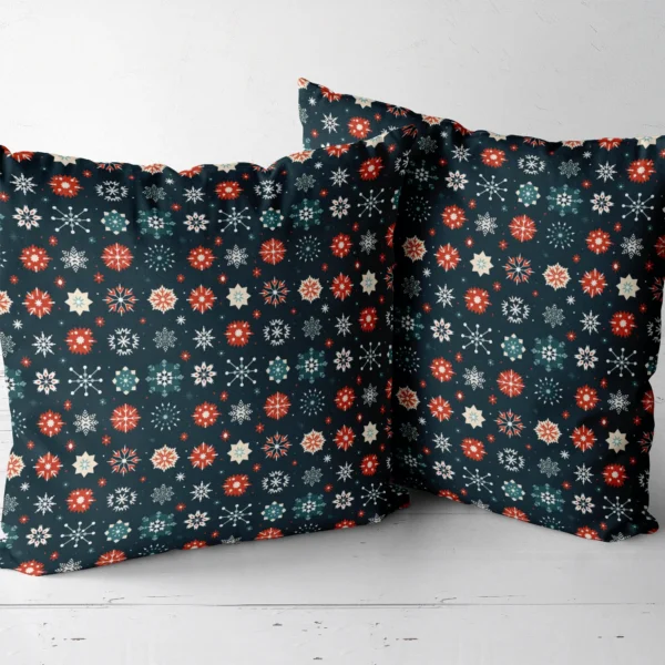 Pair of navy snowflake Christmas pillows next to one another