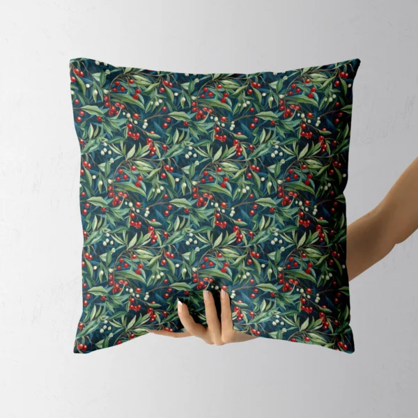 Hand holding the square navy pillow with red and cream berries