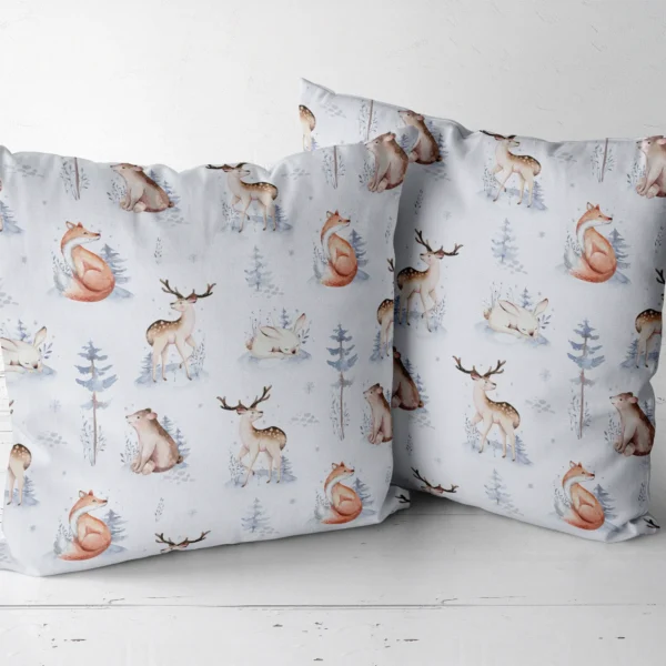 Two pale blue woodland throw pillows next to each other