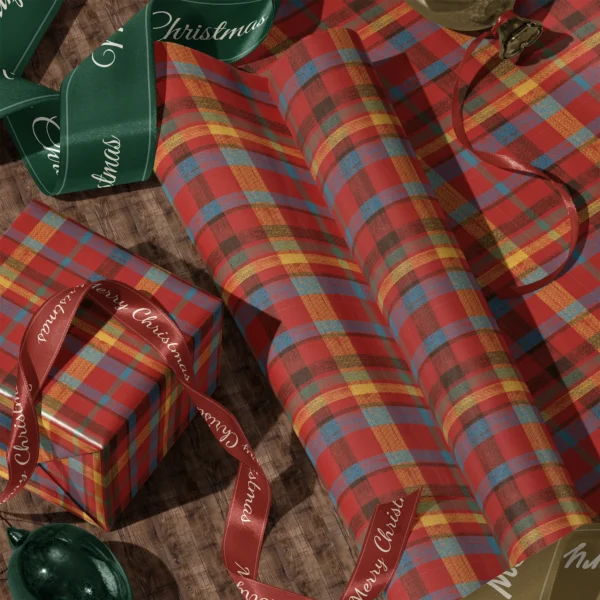 Rolls of patchwork plaid gift wrap and a wrapped box with satin ribbons on a wooden floor