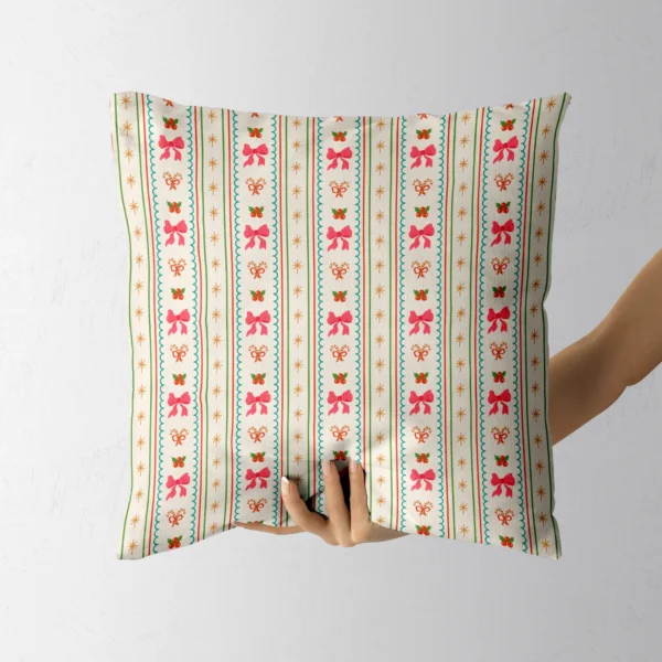 Hand holding the cream throw pillow with pink bow and candy cane stripes