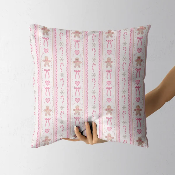Hand holding the cream and pink gingerbread throw pillow