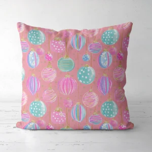 Pink pastel ornament Christmas pillow facing forward on a white floor