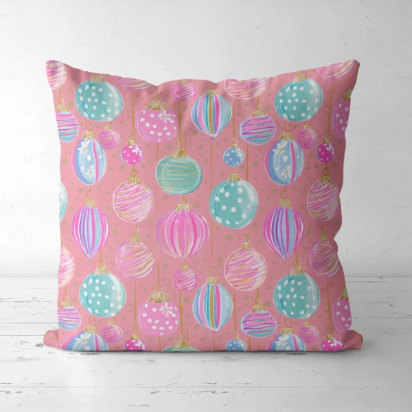 Pink pastel ornament Christmas pillow facing forward on a white floor