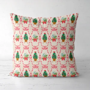 Pink ribbon frame Christmas pillow standing on a white floor, front view