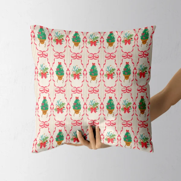 A hand holding the cream pillow with pink ribbon frames