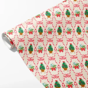 Roll of cream wrapping paper with potted Christmas trees inside pink ribbon frames, partly unrolled on white