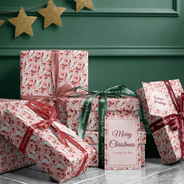 Stack of presents in pink watercolor Santa paper with ribbons and a Merry Christmas card by a dark green wall