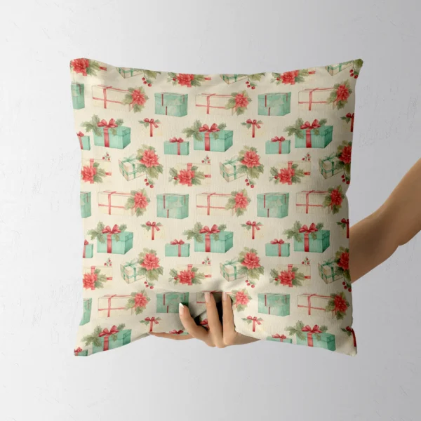 Someone holding the poinsettia and gift Christmas pillow in one hand