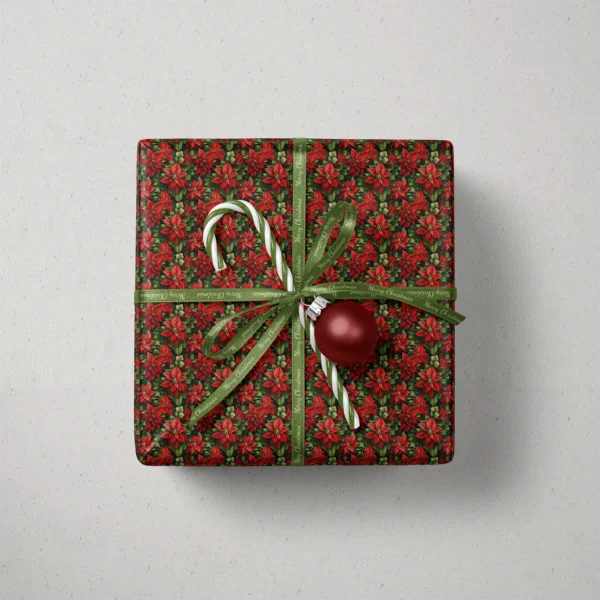 Top view of a gift in dark green poinsettia paper with a ribbon, a candy cane and a bauble