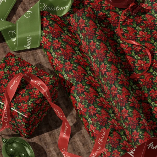 A sheet of dark green poinsettia gift wrap and a wrapped box with satin ribbons on a wooden floor