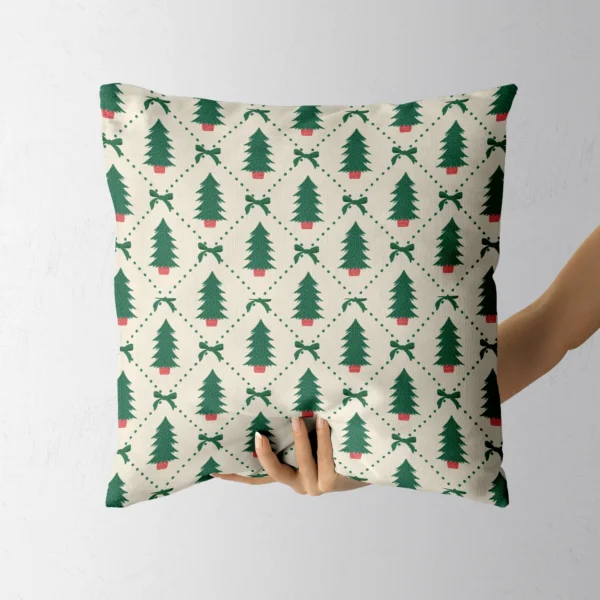 Hand holding the cream pillow with potted firs in green diamonds