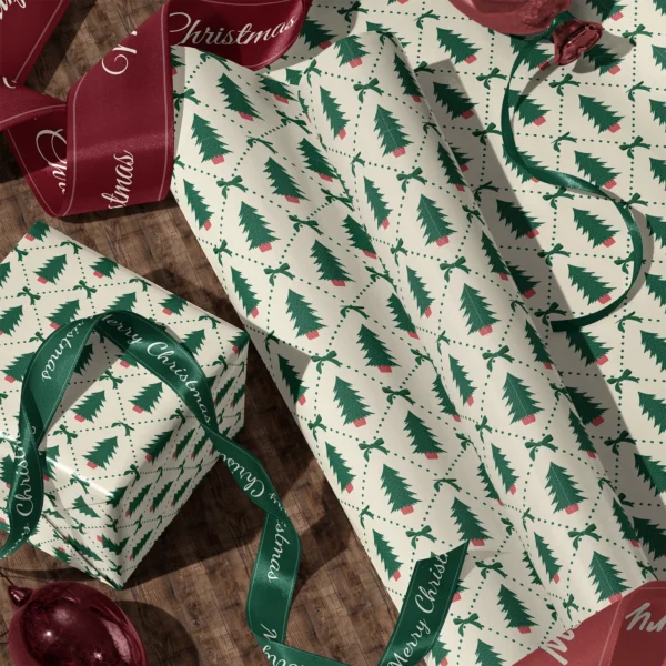 Rolls of potted tree diamond gift wrap and a wrapped box with satin ribbons on a wooden floor