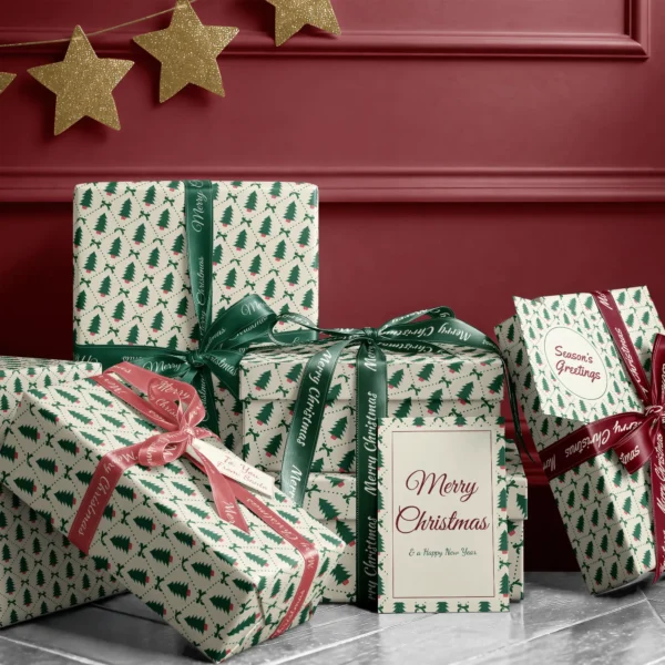 Stack of presents in potted tree diamond paper with ribbons and a Merry Christmas card by a burgundy wall