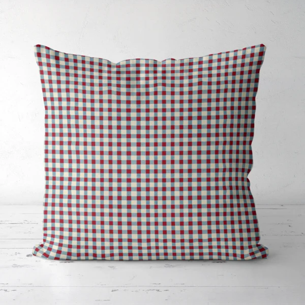 Red and blue gingham pillow standing on a white floor, front view