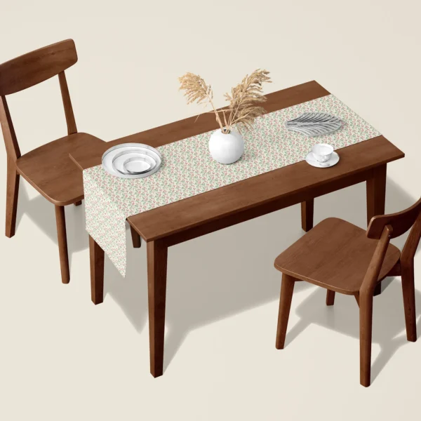 Red berry sprig Christmas table runner on a walnut dining table with two wooden chairs