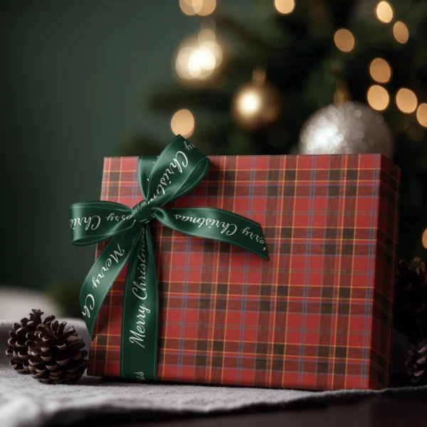 Box wrapped in red and black block plaid paper with a satin ribbon bow, Christmas tree lights behind