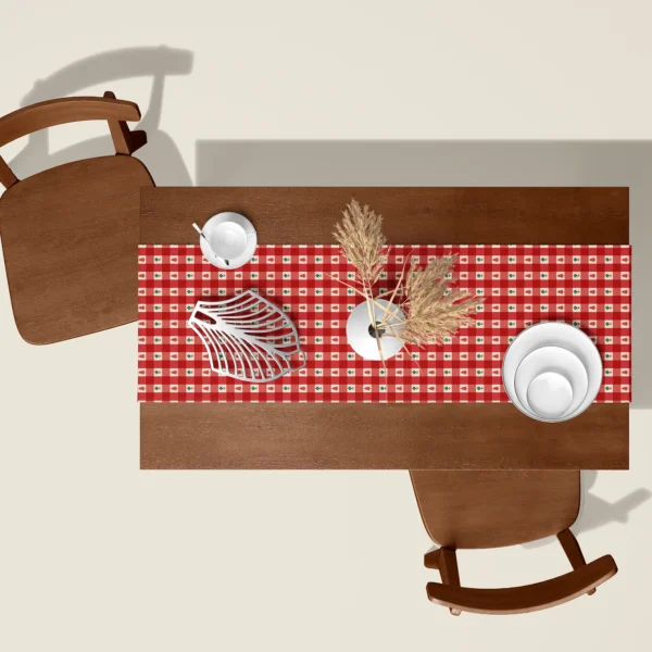 Red gingham tiny tree Christmas table runner seen from above on a walnut table with white dishes and dried pampas
