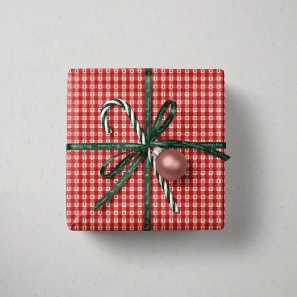 Top view of a gift in red gingham tree paper with a ribbon, candy canes and a bauble