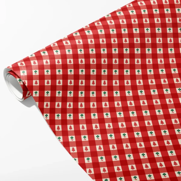 Roll of red gingham wrapping paper with tiny red trees and green flowers in the cream squares, partly unrolled on white