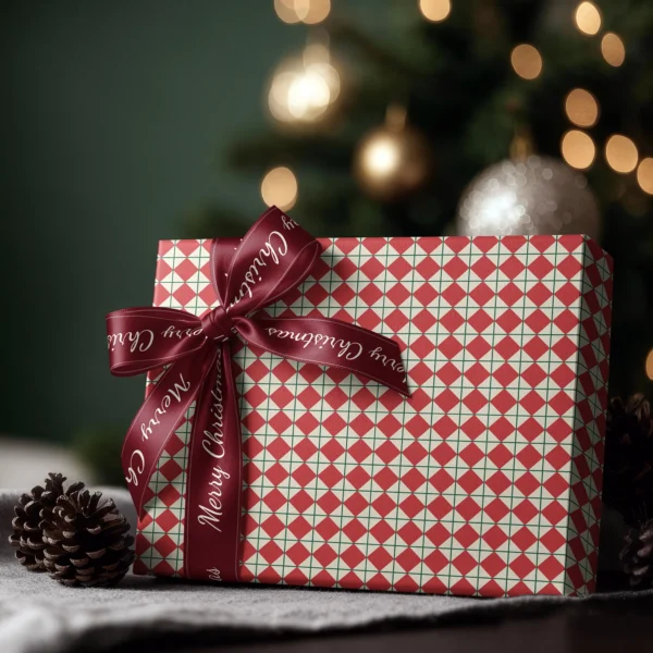 Box wrapped in red harlequin paper with a satin ribbon bow, Christmas tree lights behind