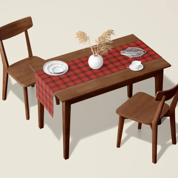 Red lumberjack check Christmas table runner on a walnut dining table with two wooden chairs