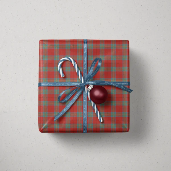 Top view of a gift in red and teal windowpane plaid paper with a ribbon, candy canes and a bauble
