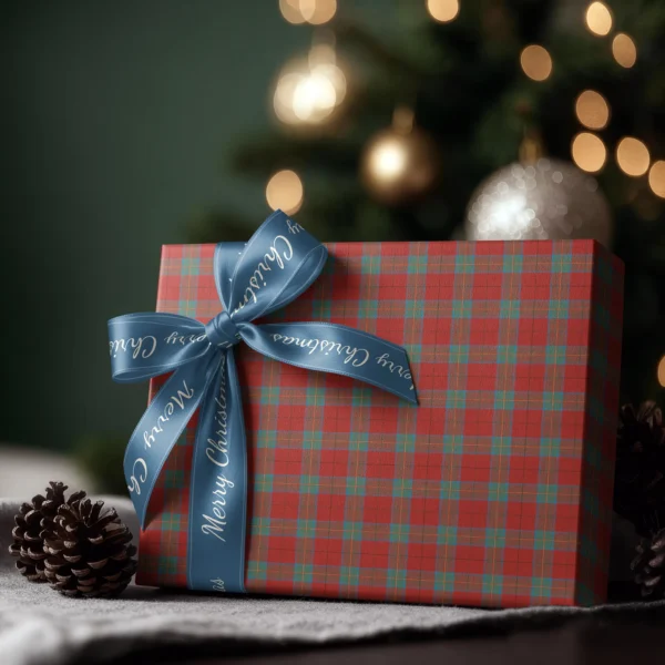 Box wrapped in red and teal windowpane plaid paper with a satin ribbon bow, Christmas tree lights behind