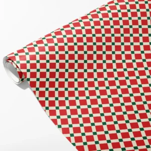 Roll of red and cream tile check wrapping paper with small green squares at the grid crossings, partly unrolled on white