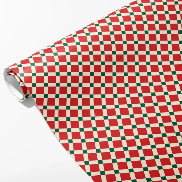 Roll of red and cream tile check wrapping paper with small green squares at the grid crossings, partly unrolled on white